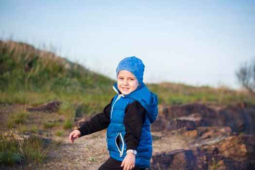 A child stands on top of a cliff and watches what is happening below. panoramic view from the top of a rocky mountain. Russia, Rostov region, skelevataya skala, the 7th wonder of the Don world. Landscape