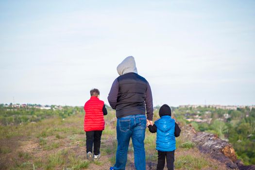 A man and children are standing on a rock and watching what is happening below. panoramic view from above. Russia, Rostov region, skelevataya skala, the 7th wonder of the Don world. Landscape