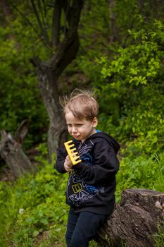 Portrait of a child with a funny facial expression. a walk in the fresh air in the park. Bright and juicy spring greenery around.