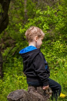 Portrait of a child with a funny facial expression. a walk in the fresh air in the park. Bright and juicy spring greenery around.
