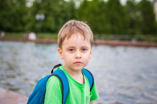 Portrait of a child, a boy against the backdrop of urban landscapes of skyscrapers and high-rise buildings in the open air. Children, Travel. Lifestyle in the city. Center, streets. Summer, a walk.