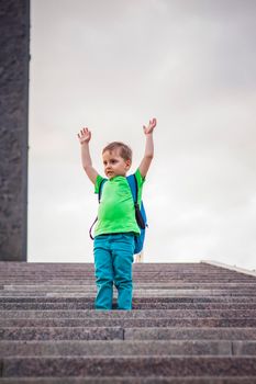 Portrait of a child, a boy against the backdrop of urban landscapes of skyscrapers and high-rise buildings in the open air. Children, Travel. Lifestyle in the city. Center, streets. Summer, a walk.