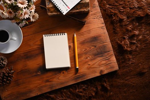 Top view empty notebook, pencil and coffee cup on wooden background.