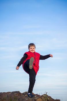 A child stands on top of a cliff and watches what is happening below. panoramic view from the top of a rocky mountain. Russia, Rostov region, skelevataya skala, the 7th wonder of the Don world. Landscape