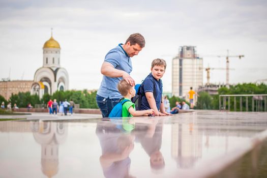 Portrait of a child, a boy against the backdrop of urban landscapes of skyscrapers and high-rise buildings in the open air. Children, Travel. Lifestyle in the city. Center, streets. Summer, a walk.