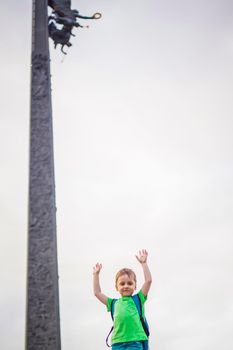 Portrait of a child, a boy against the backdrop of urban landscapes of skyscrapers and high-rise buildings in the open air. Children, Travel. Lifestyle in the city. Center, streets. Summer, a walk.