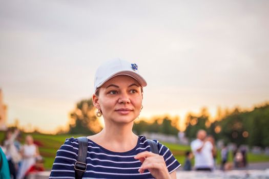 Portrait of a girl in a cap on the background of an open-air urban landscape. Travel. Lifestyle in the city. Center, streets. Summer, a walk.