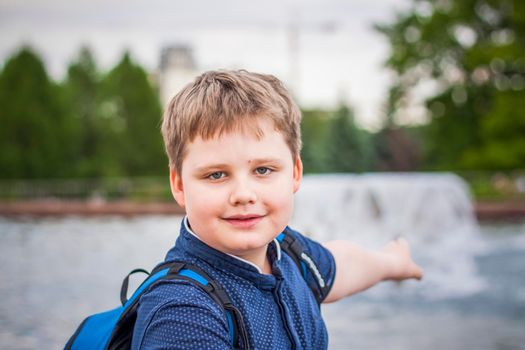 Portrait of a child, a boy against the backdrop of urban landscapes of skyscrapers and high-rise buildings in the open air. Children, Travel. Lifestyle in the city. Center, streets. Summer, a walk.