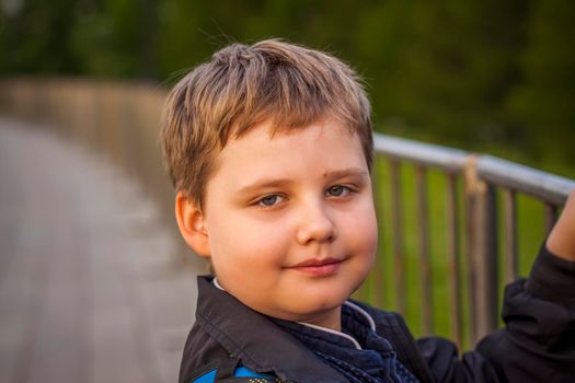 Portrait of a child, a boy against the backdrop of urban landscapes of skyscrapers and high-rise buildings in the open air. Children, Travel. Lifestyle in the city. Center, streets. Summer, a walk.