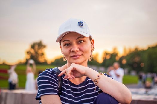 Portrait of a girl in a cap on the background of an open-air urban landscape. Travel. Lifestyle in the city. Center, streets. Summer, a walk.
