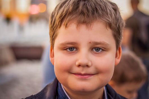 Portrait of a child, a boy against the backdrop of urban landscapes of skyscrapers and high-rise buildings in the open air. Children, Travel. Lifestyle in the city. Center, streets. Summer, a walk.