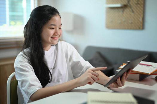 Teenage student studying online or doing homework on digital tablet.