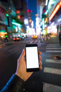 hand holding phone at night in the city