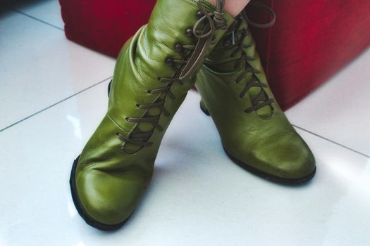 A pair of green leather women's boots with shoelaces and heels