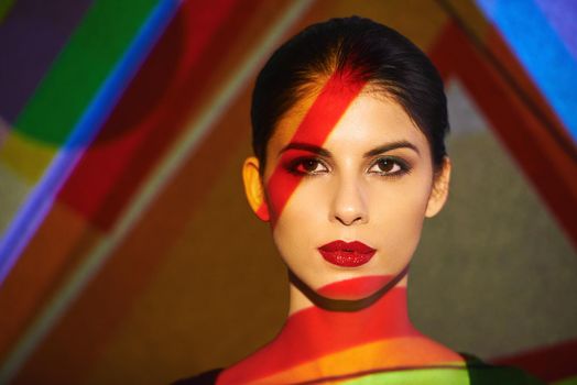 A beautiful model in the studio covered with a myriad of abstract lighting.