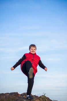 A child stands on top of a cliff and watches what is happening below. panoramic view from the top of a rocky mountain. Russia, Rostov region, skelevataya skala, the 7th wonder of the Don world. Landscape