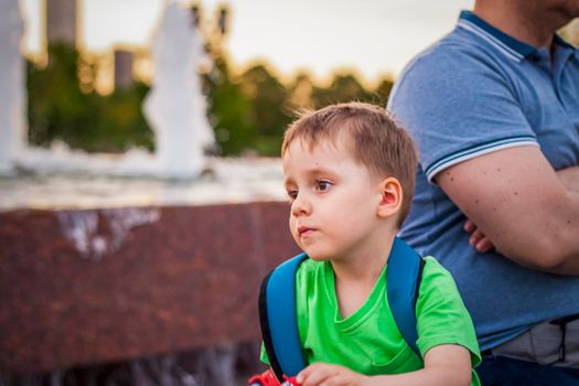 Portrait of a child, a boy against the backdrop of urban landscapes of skyscrapers and high-rise buildings in the open air. Children, Travel. Lifestyle in the city. Center, streets. Summer, a walk.