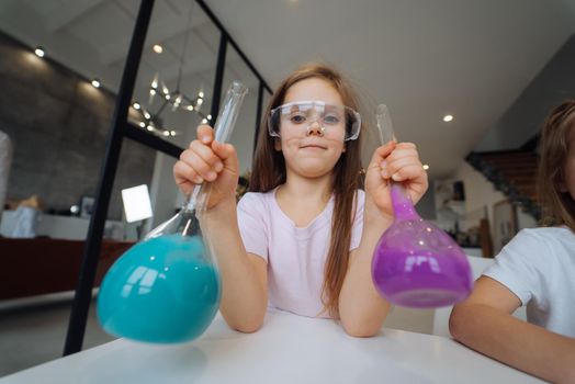 Girl making chemical experiments at home, close view.