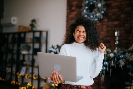 Nice attractive lovely overjoyed crazy cheerful cheery wavy-haired girl holding in hands laptop, goal achievement