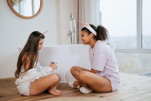 Two girls talking on the bathroom floor