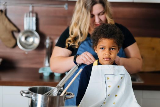 Happy family having fun in the kitchen. Mom teaches her little daughter to cook.