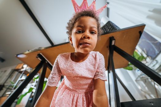 Little girl playing under the table in the room