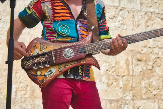 Musician playing live with a colorful weird shaped electric guitar