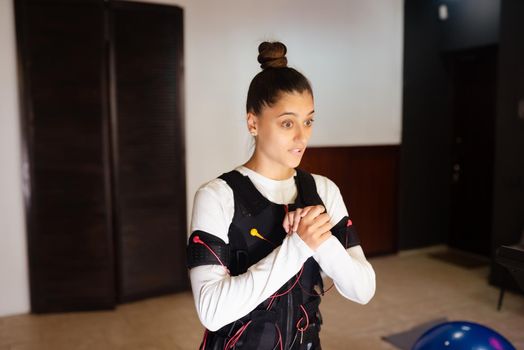 Girl doing exercises in a suit with cables.