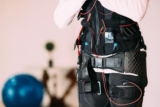 Girl doing exercises in a suit with cables.