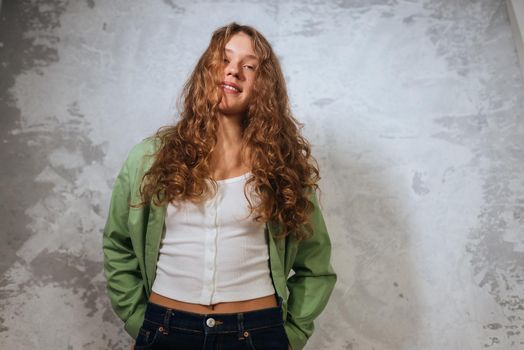 Pretty female looking at camera. Studio shot of good-looking beautiful woman isolated against blank studio wall.