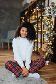 Beautiful young african american woman on the floor happy face smiling and looking at the camera. Positive person.