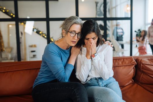 Grandmother comforting her sad granddaughter at home. Support concept