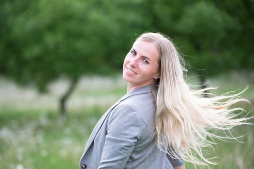 Woman blonde with long hair on the street. Plain girl with luxurious strands