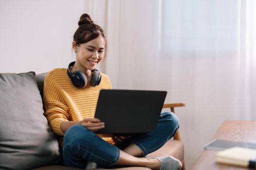 Young asian woman having conversation chatting while using laptop at house. Work at home, Video conference, Online meeting video call, Virtual meetings, Remote learning and E-learning