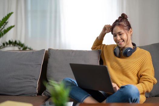 Young asian woman having conversation chatting while using laptop at house. Work at home, Video conference, Online meeting video call, Virtual meetings, Remote learning and E-learning