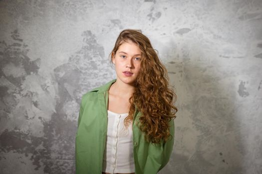 Pretty female looking at camera. Studio shot of good-looking beautiful woman isolated against blank studio wall.