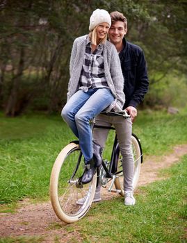 A young couple enjoying a bike ride outdoors together.