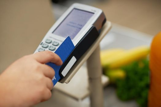 Closeup shot of a credit card payment being made in a grocery store.