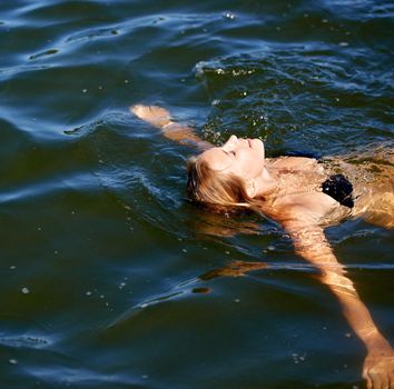 Shot of an attractive young woman floating on her back in a lake.