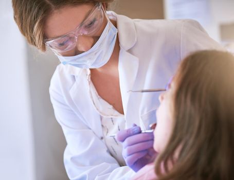 Cropped shot of a dentist examining a little girls teeth.