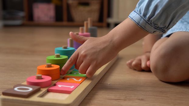 Happy Little Preschool Toothless Girl Playing With Colored Wooden Toy. Kids Learn To Count By Playing Teaches Numbers At Home. Child Listening To Music In Big White Headphones. Childhood, Education.