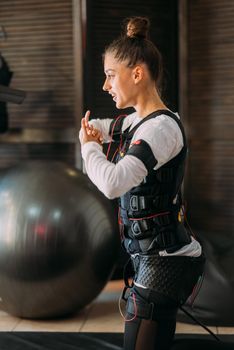 Girl doing exercises in a suit with cables.