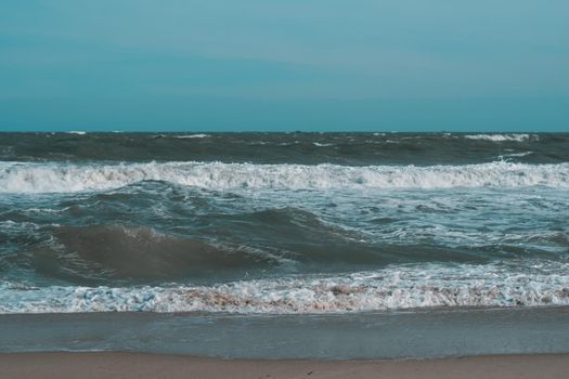 Ocean storm waves dramatically crashing splashing. Sky horizon line. Sea water edge, nature front view marine wallpaper, design. Bad weather cloudy overcast. Dark green turquoise blue tone pale matte.