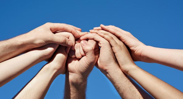 Cropped shot of a group of hands holding on to each other.