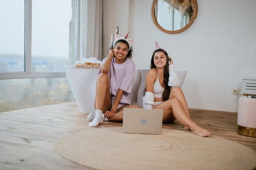 Two beautiful young women relaxing on the bathroom floor