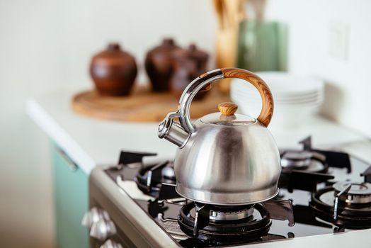 Kettle heats the gas stove. Interior of modern kitchen