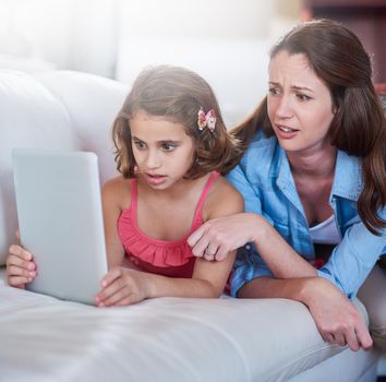 Cropped shot of a mother and her daughter using wireless technology at home.