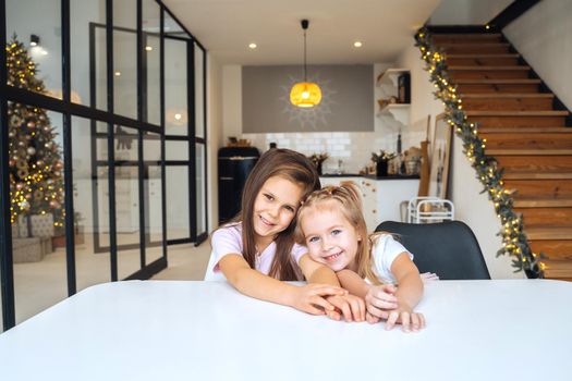 Two little girls at the table looking at the camera