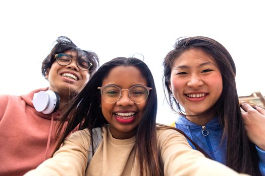 Selfie time. Happy multiracial gen z friends take picture of themselves. Multi-ethnic teenagers having fun together looking at camera. Technology and social media concept.