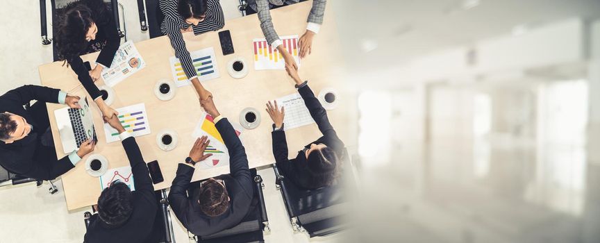 Group business people handshake at meeting table in office together with confident shot from top view . Young businessman and businesswoman workers express agreement of investment deal. broaden view